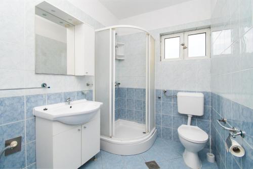 ein Badezimmer mit Waschbecken, Toilette und Dusche in der Unterkunft Apartments Jadranka in Grebaštica