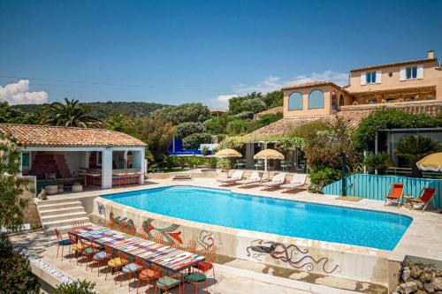una piscina con sedie e una casa di Villa No Chichi - 12BR-33P - Collines Grimaud a Grimaud