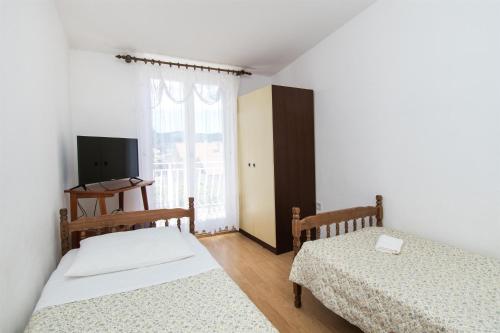 - une chambre avec 2 lits et une fenêtre dans l'établissement Apartments Zivana, à Žaborić