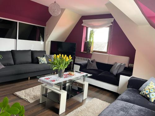 a living room with purple walls and a table at Apartament Podczerwone in Czarny Dunajec