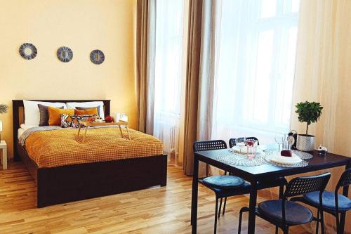a bedroom with a bed and a table and chairs at Centrally located Studio Apartment in Riga