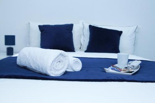 un letto con due asciugamani e una tazza sopra di Lovely Apartment with free parking on premises. a Londra