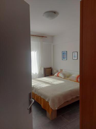 a bedroom with a bed and a window at Mala placa in Senj