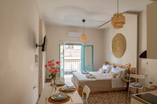 ein Wohnzimmer mit einem Bett und einem Tisch mit Blumen in der Unterkunft Four Seasons in Chania