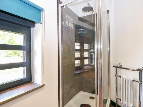 um chuveiro na casa de banho com uma janela em The Masters House em Hassocks