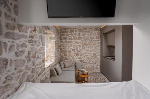a bedroom with a stone wall with a bed and a tv at Murvica resport in Murvica