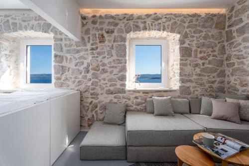 a living room with a couch and two windows at Murvica resport in Murvica
