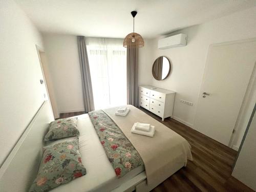 a bedroom with a bed with a dresser and a mirror at MT SUITES BUDAPEST in Budapest