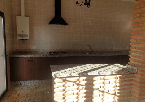 a kitchen with a counter with a sink and a brick wall at Villa el Mirador in Algodonales