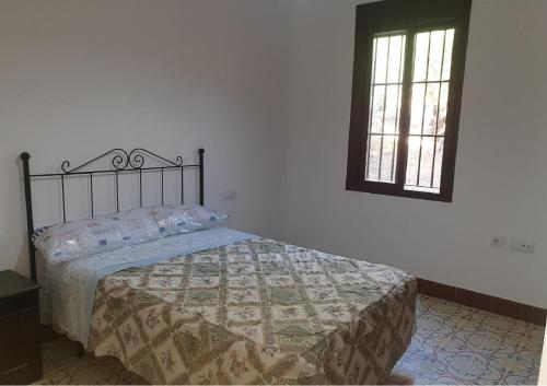 a bedroom with a bed and a window at Villa el Mirador in Algodonales