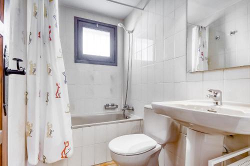 a white bathroom with a toilet and a sink at Jardins I 22 Roses - Immo Barneda in Roses