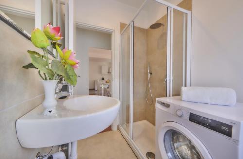 a bathroom with a sink and a washing machine at Casa Iris in Varenna