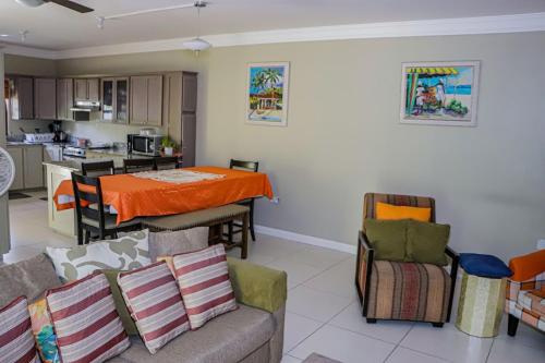 a kitchen and a living room with a couch and a table at Water Mills- Beach Apartments in Mammee Bay