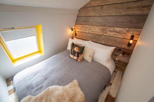 a bedroom with a large bed with a wooden wall at higgihaus Apartment 6 Clare Street Aparthotel Central Location in Bristol
