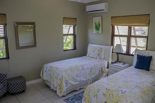 a bedroom with two beds and a mirror at Water Mills- Beach Apartments in Mammee Bay