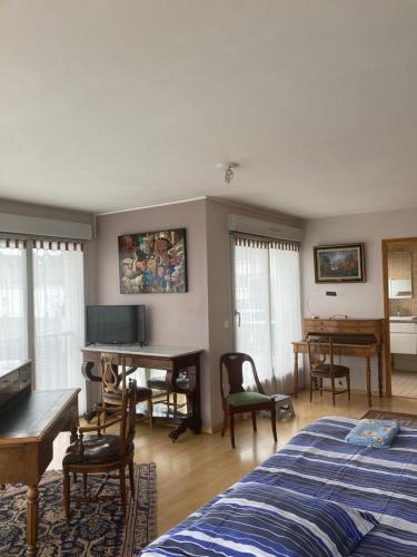 une chambre avec un lit, un bureau et des chaises dans l'établissement Suite Magdelaine - Vue Cathédrale, à Reims