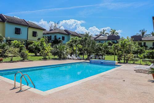 a swimming pool in front of a house at Water Mills- Beach Apartments in Mammee Bay