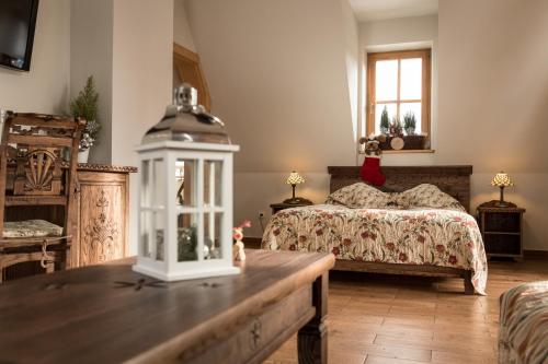 a bedroom with a bed and a table in front of it at Butorowy Dwór in Kościelisko