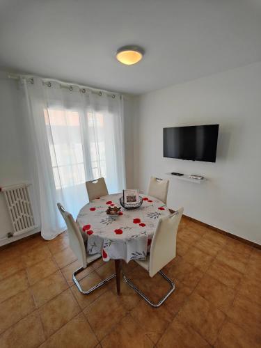 une salle à manger avec une table avec des chaises et une télévision dans l'établissement Charmant appartement au cœur de Nice - proche de tout !, à Nice