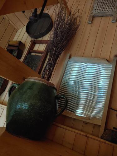 a green vase sitting on a table next to a window at POČITNIŠKA HIŠA PRLEČKA in Miklavž pri Ormožu