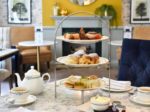a table with three tiers of pastries and cups of coffee at Villiers Hotel in Buckingham