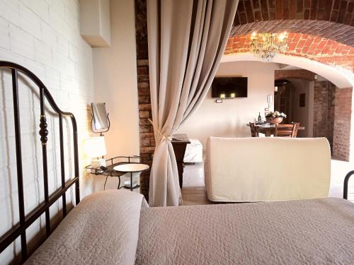 a bedroom with a bed and a dining room at Teresa Belvedere Rooms&HolidayApartments Camere&Appartamenti in Castellinaldo