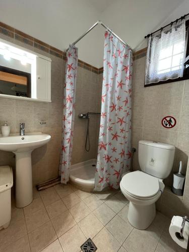 a bathroom with a toilet and a sink and a tub at Starfish in Koropi