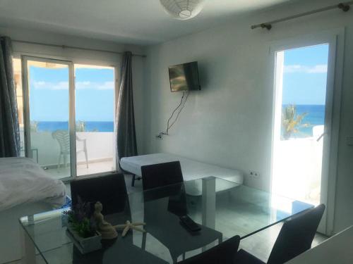 sala de estar con escritorio y vistas al océano en Thee Ibiza Suites - Ushuaia Beach, en Playa d'en Bossa