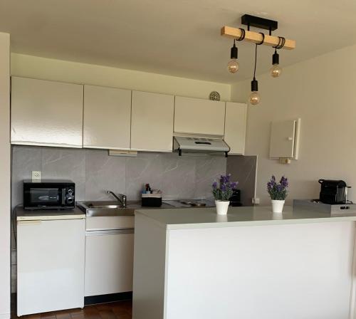 une cuisine avec des placards blancs et un comptoir dans l'établissement Lavand'in Durbuy, à Durbuy