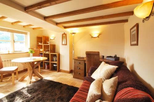 a living room with a couch and a table at Heather Cottage in Kirk Ireton