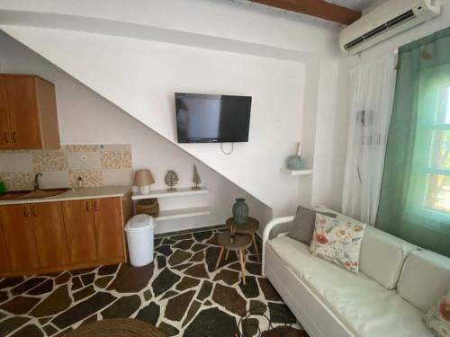 salon z kanapą i telewizorem z płaskim ekranem w obiekcie red2 guest house w mieście Flampouria