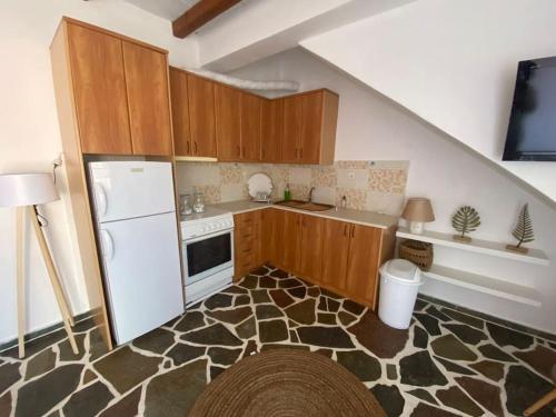 una cucina con armadi in legno e frigorifero bianco di red2 guest house a Flampouria