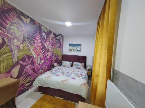 - une chambre avec un lit et du papier peint tropical dans l'établissement HONEYMOON APARTMAN, à Sokobanja