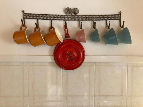 a rack of coffee mugs hanging on a wall at Authentic Vila Nona by NYC Interior Architect in Susak