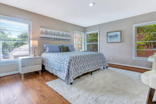 a bedroom with a bed and two windows at The Oasis at West U Top-Floor Heated Pool & Spa in Houston