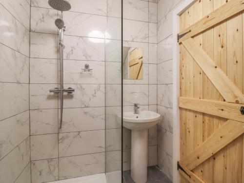 a bathroom with a shower and a sink at Cuckoo Cottage in Keighley