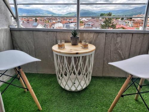 a table on a balcony with two chairs and a window at Chic and Cozy Apartment on the Main Pedestrian Street in Struga