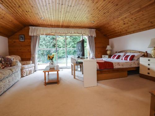 a bedroom with a bed and a desk in a room at Llys Offa in Wynnstay