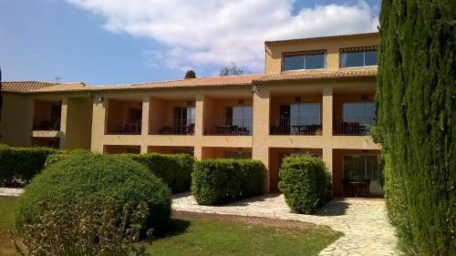 a large building with bushes in front of it at Hotel Bellerive in Rasteau