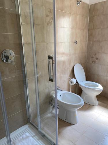uma casa de banho com um WC e uma cabina de duche em vidro. em La Verna House em Chiusi della Verna