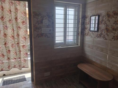 Baño pequeño con banco y ventana en Noah Home, en Velankanni