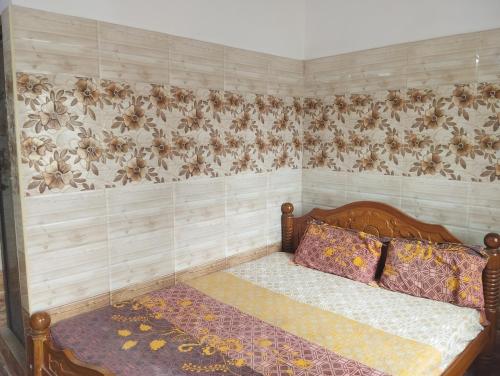 Un dormitorio con una cama con papel pintado floral. en Noah Home, en Velankanni