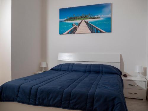 a bedroom with a blue bed and a painting on the wall at Villa Patty in Naples