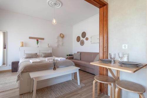 a bedroom with a bed and a couch and a table at Avenida & Mercado by Home Sweet Home Aveiro in Aveiro