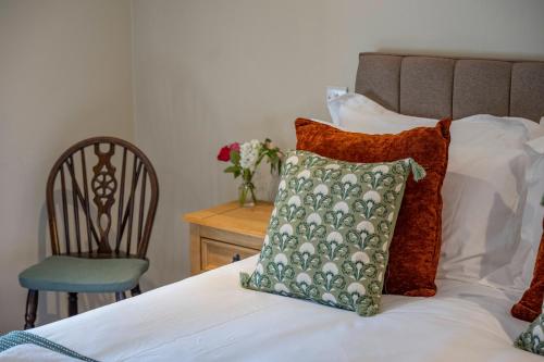 a bedroom with a bed with a pillow and a chair at Cross Keys Inn Ettrickbridge in Ettrickbridge End