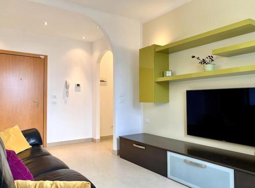 a living room with a couch and a flat screen tv at La Dolse Ca' - Lago di Garda in Brenzone sul Garda