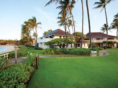 une maison avec des palmiers et une cour verdoyante dans l'établissement Kiahuna Plantation Resort Kauai by OUTRIGGER, à Koloa