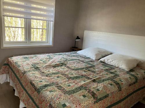 - un lit avec une couette et deux oreillers dans une chambre dans l'établissement Svanen B&B, à Karlsborg