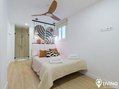 a bedroom with a bed and a ceiling fan at Living Las Canteras Homes - BEACHFRONT IN STYLE in Las Palmas de Gran Canaria