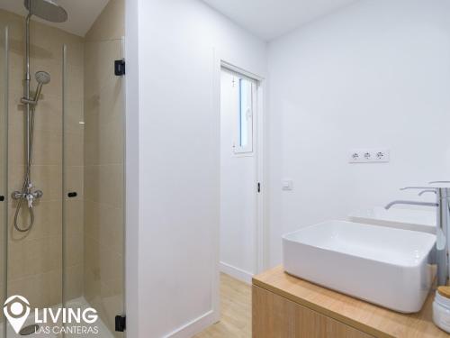 W łazience znajduje się biała umywalka i prysznic. w obiekcie Living Las Canteras Homes - BEACHFRONT IN STYLE w mieście Las Palmas de Gran Canaria